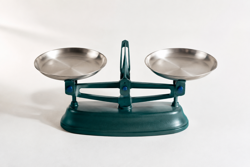 AI-generated still life: a teal balance scale, representing value and trade-offs.